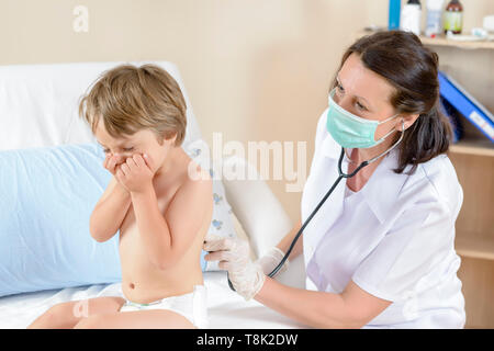 Cute boy coughing being consulted by physician Stock Photo