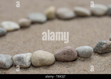 lines of pebbles on sandy background macro Stock Photo