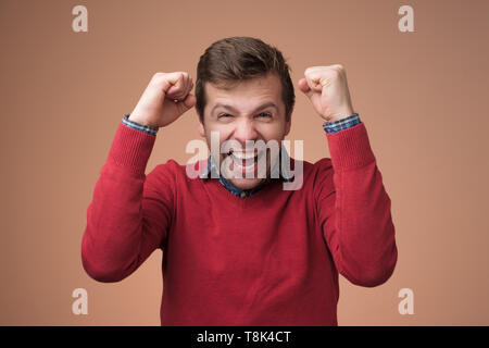 happy man raising hands up being happy and excited Stock Photo