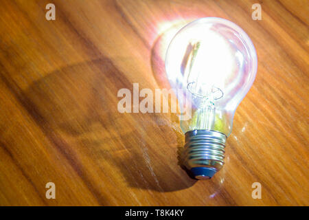 Retro decorative lamp Edison vintage style lying on a wooden surface. Stock Photo