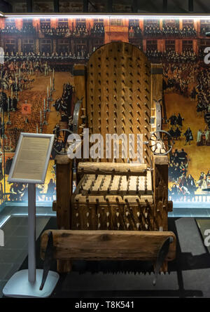 One of the cruel exhibits in Torture Museum Bruges, 'Oude Steen' - Chair of Torture. This terrible device of the Middle Ages is covered with spikes Stock Photo