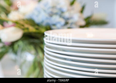 Set of clean dishes and cutlery on table in kitchen Stock Photo