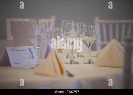 Round wedding dinning table with chairs, flowers and candles carefully set. Close up of wedding invitationBohemian event decorations for a special cel Stock Photo