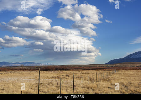 barbed wire fence and wave cloud forming over the Owens Valley near Bishop California Stock Photo