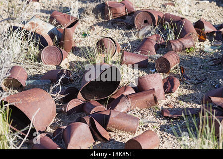 old cans rusting in the desert where they were thrown years ago Stock Photo