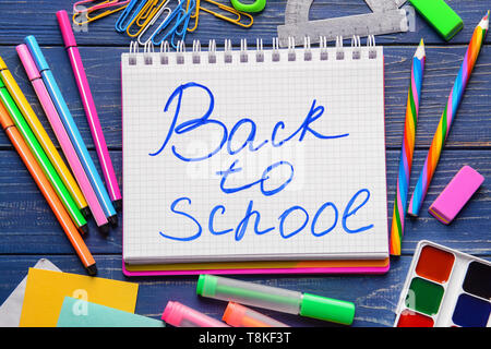 Notebook with words BACK TO SCHOOL and set of stationery on wooden background Stock Photo