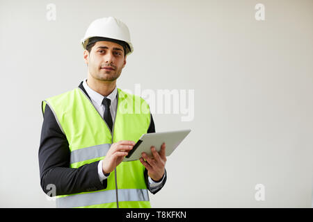 Pensive Engineer Holding Tablet Stock Photo