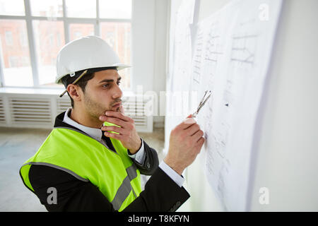 Engineer Thinking over Plans Stock Photo