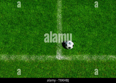 soccer ball classic in black and white on penalty spot on green artificial turf Stock Photo
