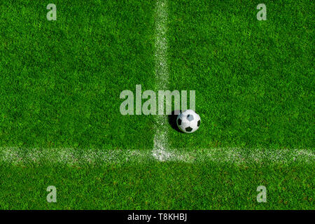 soccer ball classic in black and white on penalty spot on green artificial turf Stock Photo