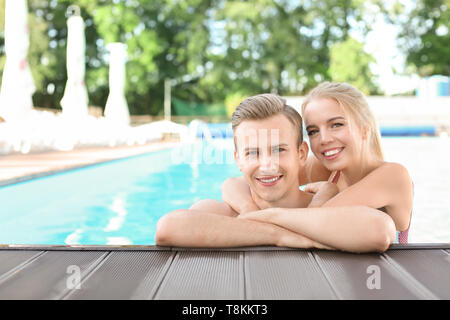 Happy young couple resting in swimming pool at resort Stock Photo