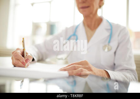 Doctor Writing at Desk Stock Photo