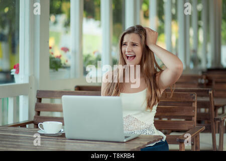 Stressed sad woman feeling tired worried about problem sitting at table with laptop, frustrated depressed girl troubled with reading bad news online,  Stock Photo