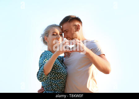 Cute young couple making heart with their hands outdoors Stock Photo