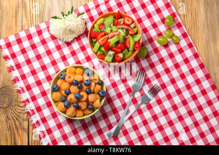 Delicious fruit salads in bowls on table Stock Photo
