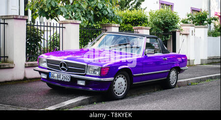 Strasbourg, France - May 19, 2017: Beautiful vintage purple convertible cabriolet Mercedes-Benz 300 Sl parked in front of French luxury house in calm neighborhood Stock Photo