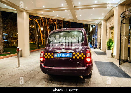 Baku, Azerbaijan - May 1, 2019: Rear view of traditional Azeri taxi cab hackney carriage taxi in front of Hyatt luxury five star hotel in Baku Stock Photo