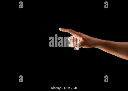 Young man using virtual screen on dark background Stock Photo