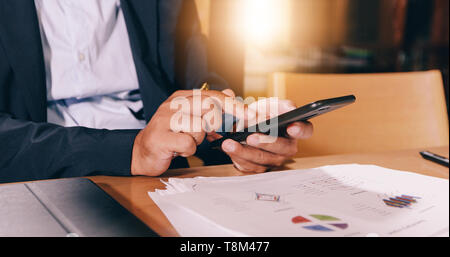 Businessmen  are using mobile and touch smart phone for Communication and checking on business people in office background Stock Photo