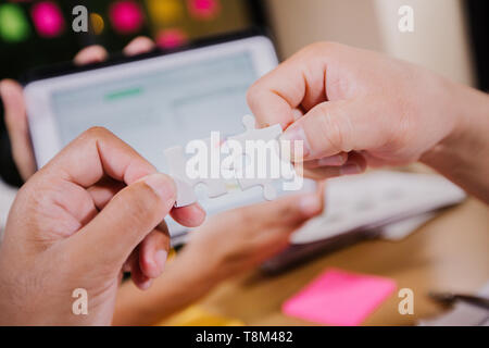 Businessmen Holding Jigsaw Puzzle ,business solutions for successful teamwork, teambuilding unity concept Stock Photo