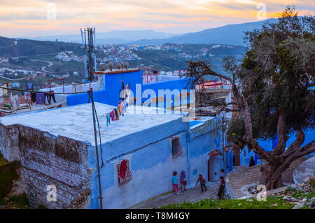 Chefchaouen, Morocco : General view at dusk of the blue-washed medina old town with children playing in the street. Stock Photo