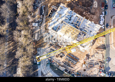 aerial top view of urban construction area with high yellow tower cranes and other building equipment Stock Photo