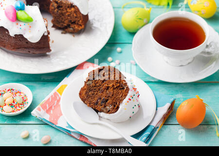 Easter cake on a white plate with colorful eggs. Blue wooden background. Stock Photo