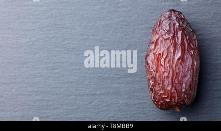 Fresh Medjool Dates. Slate stone background. Top view. Copy space. Stock Photo