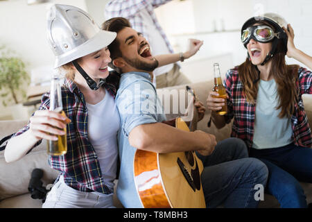 Group of friends playing guitar and partying at home Stock Photo