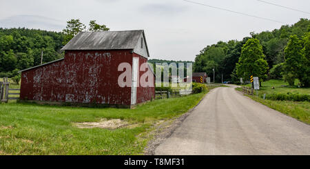 Claysville, Pennsylvania/USA- June 8, 2018:  Faded red barn on a country road in rural Appalachia. Stock Photo