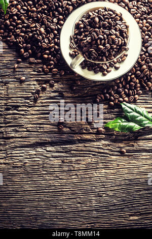 Top of view cup full of coffee beans on rustic oak table Stock Photo