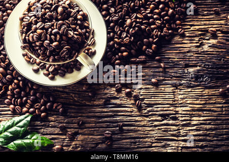 Top of view cup full of coffee beans on rustic oak table Stock Photo