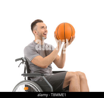 Young basketball player sitting in wheelchair on white background Stock Photo