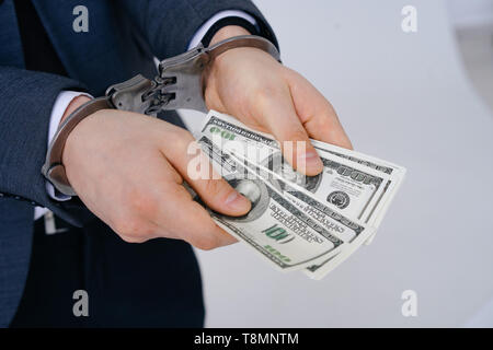 Businessman in handcuffed hold dollar bribe Stock Photo