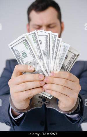 Businessman in handcuffed hold dollar bribe Stock Photo
