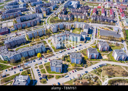Aerial city view with crossroads and roads, houses, buildings, parks and parking lots. Stock Photo