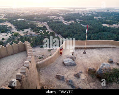Woman enjoying sunset view from Dhayah fort in Ras Khaimah emirate in UAE aerial Stock Photo