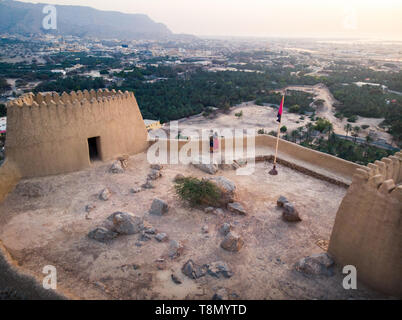 Couple enjoying sunset view from Dhayah fort in Ras Khaimah emirate in UAE aerial Stock Photo
