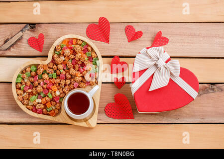 colorful dried fruits,tea and a heart-shaped gift on a wooden background Stock Photo