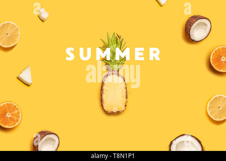 Creative summer composition of tropical fruit juices on a yellow background: oranges, coconuts, lemons, pineapples. Stock Photo
