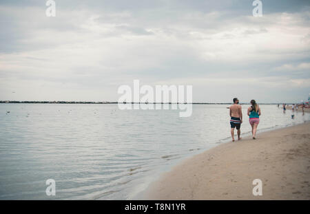 A couple walking on a sandy beach Stock Photo