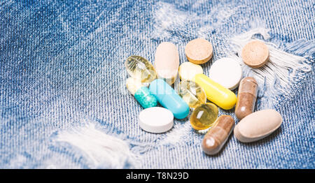 Medicine prescription. Health care and illness. Dose and addiction. Drug addiction. Medicine and treatment concept. Drugs on denim background. Set of colorful pills. Mixing medicines. Fast treatment. Stock Photo