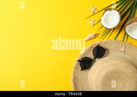 Straw hat, sunglasses, starfishes, coconuts and palm leaf on color background space for text and top view. Summer vacation backdrop Stock Photo