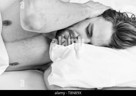 How to get up in morning feeling fresh. Late morning overslept. Man handsome guy lay in bed in morning. Tips on how to wake up feeling fresh and energetic. Morning routine tips to feel good all day. Stock Photo