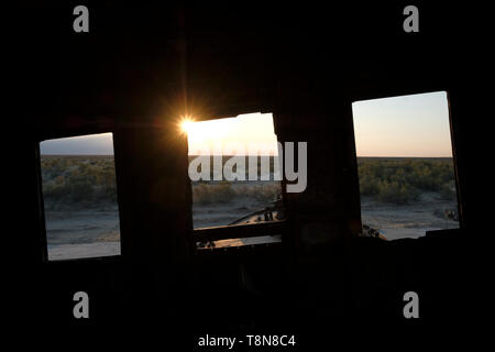 View through an abandoned ship in the former Uzbek fishing port of Muynak, or Mo‘ynoq, also spelled as Muynak and Moynaq which is now more than 75 miles away from the shores of the Aral Sea which was once the 4th largest in the world and now called the Aralkum Desert. Republic of Karakalpakstan, Uzbekistan Stock Photo