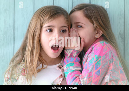 Studio Portrait Of Two girls telling a secret. Best friends Stock Photo