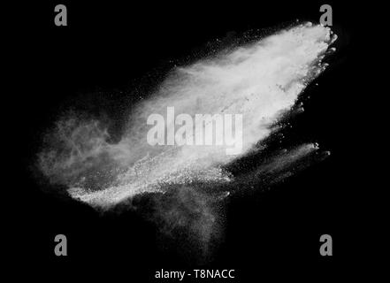 Freeze motion of white dust explosions isolated on black background. Stock Photo