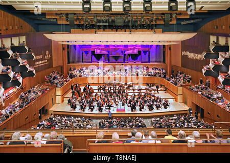 Interior of the Royal Festival Hall on London's South Bank. Opened in 1951, refurbished in 2007. Orchestra on stage, audience seated. Stock Photo