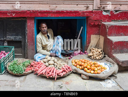 Man selling vegetables in the street market in the Old City of Varanasi, India Stock Photo