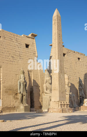 The entrance of the Temple of Luxor with an obelisk and statues of Ramesses II Stock Photo